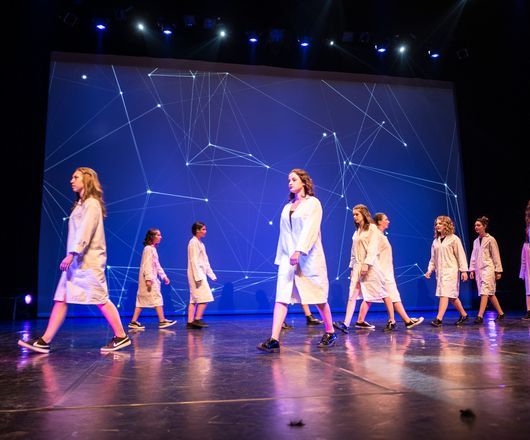 groupe de jeunes en blouse blanche se promenant sur une scène