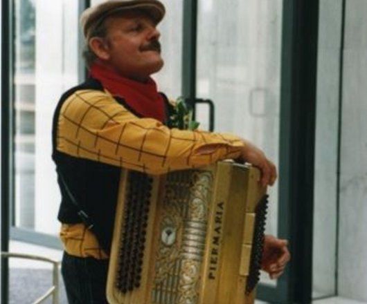 Photographie de l’opération « Muguet » à l’Hôtel de Région en présence de conseillers régionaux : joueur d'accordéon en costume d'époque (21 mai 1995) (Archives Service Presse).