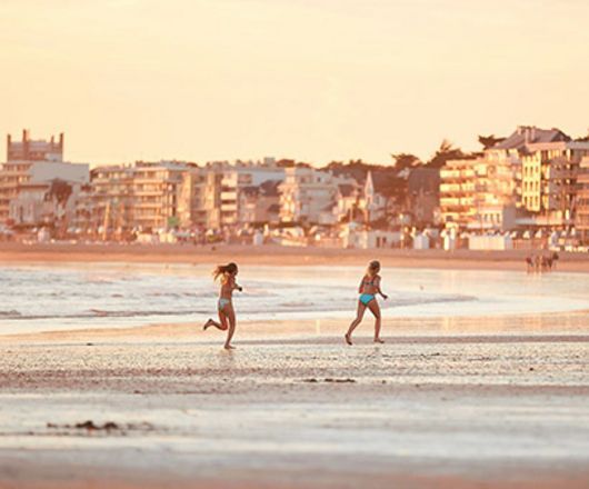 Coucher de soleil sur la plage de Pornichet et deux enfants courant sur la plage