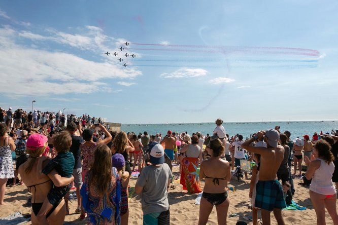 une foule estival sur la plage regarde dans le ciel 8 avions des ailes bleues