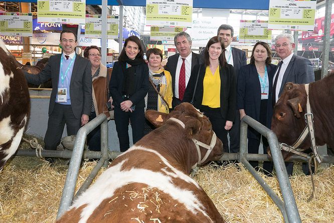 Christelle Morançais, présidente du Conseil régional des Pays de la Loire et groupe de personne, sur le stand, devant des vaches