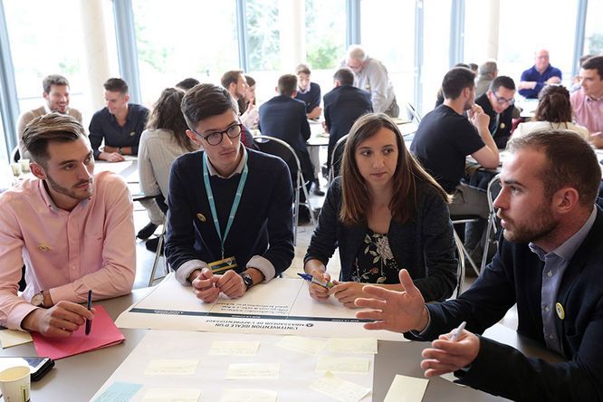 ateliers de petits groupes de 5 à 6 personnes autour de tables dans une salle