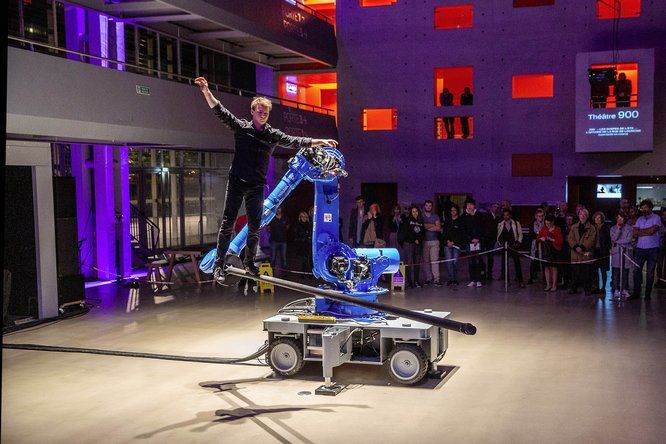 Artiste de cirque en équilibre sur un bras robotisé