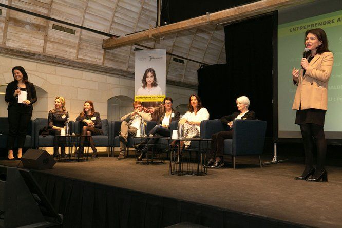 intervention de Christelle Morançais debout sur une scène, entourée de 7 femmes assises 