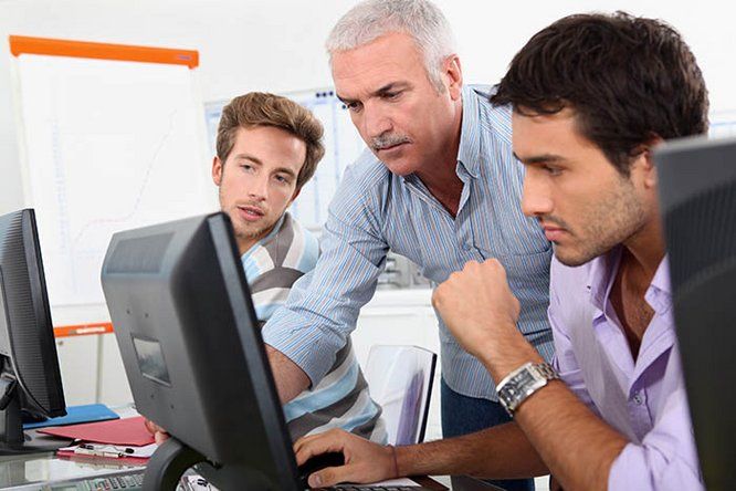 3 hommes devant un ordinateur