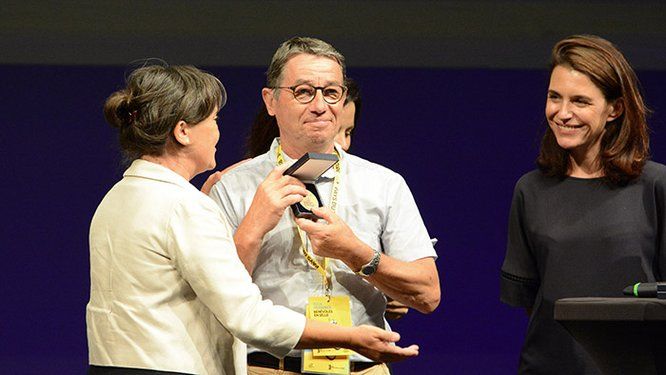 Christelle Morançais rementant une médaille du bénvolat au Tour de France à un monsieur bénévole d'une association
