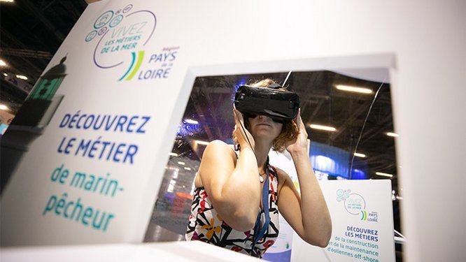 Une visiteuse portant un casque virtuel à l'exposition "La Mer XXL"