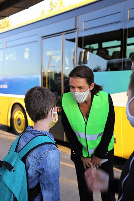Christelle Morançais parle avec un écolier devant un car Aléop