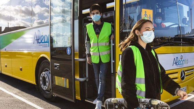 deux collégiens masqués qui descendent d'un car scolaire ALEOP