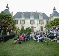 comédiens sur une scène dans les jardins d'un château, spectateurs face à eux sur des bancs