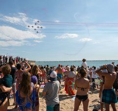 une foule estival sur la plage regarde dans le ciel 8 avions des ailes bleues