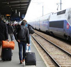 voyageurs de dos sur le quai d'une gare et TGV sur la voie
