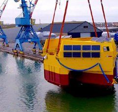 plateforme flottante suspendue à une grue dans les chantiers navals