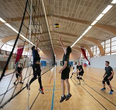 Lycéens jouant au volley dans un gymnase 