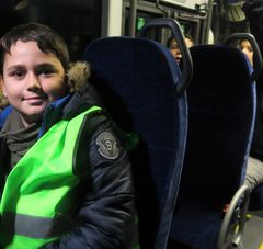 Jeune garçon dans un bus équipé d'un gilet fluorescent