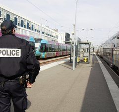 policier de dos sur le quai d'une gare, trains ter à quais