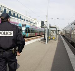 policier de dos sur le quai d'une gare, trains ter à quais