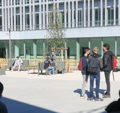 Vue d'une cour de lycée avec des groupes de lycéens masqués