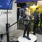 une jeune femme teste la plateforme de mouvement sur le stand Cyberith